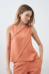 Blusa sin mangas color durazno, confeccionada en lino con efecto desflecado.
