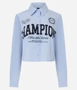Camisa de manga larga, cuello camisero, abotonada, con rayas verticales finas celestes y blancas, y estampado grande en negro con la palabra "CHAMPION".