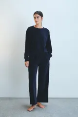 Conjunto de buzo y pantalón de terciopelo azul marino. El buzo es de corte holgado con cuello redondo y mangas largas. El pantalón es de corte recto y ancho, con cintura elástica ajustable con cordón.