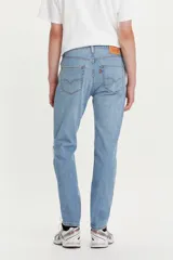 Jean de denim celeste claro con rotura en la rodilla, corte slim fit y tiro medio.