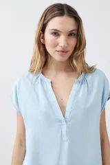 Blusa celeste de lyocell con cuello en V y mangas cortas.