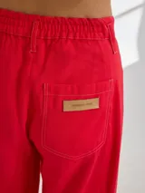 Pantalón negro de pierna ancha con tiro medio alto y pretina elastizada en la espalda. Presenta bolsillos plaque en delantera y espalda.