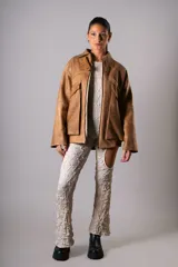 Campera estilo bomber confeccionada en cuero vacuno color marrón claro, de estructura firme y calce holgado.