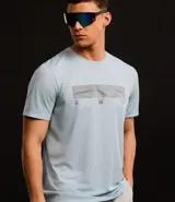 Remera deportiva celeste de poliéster con tecnología Dry, cuello redondo y mangas cortas. Estampa geométrica horizontal en el pecho y recortes en las mangas.