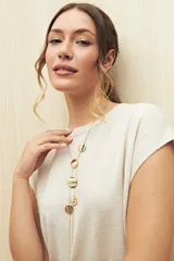 Chaleco color crudo de tejido de punto con cuello redondo y sisas amplias. Tiene corte recto con aberturas laterales en el ruedo.