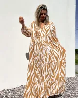 Vestido largo tipo túnica con estampado de cebra en tonos beige y crudo, con cuello en V y mangas 3/4.