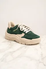 Zapatillas deportivas de gamuza verde con detalles en cuero color crema, cordones blancos y suela chunky color crema.