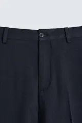 Pantalón de vestir azul marino, de corte slim fit, confeccionado en tejido con 17% de lana. Cuenta con bolsillos frontales y traseros de doble vivo con botón. Cierre frontal con cremallera y botón.