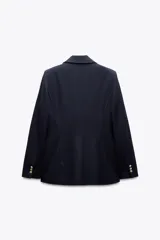 Blazer negra entallada con cuello solapa, manga larga con hombreras, bolsillos delanteros con solapa y cierre frontal con botones dorados.