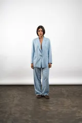 Blazer celeste de lino, con solapas de muesca, cierre frontal con dos botones, mangas largas con puños abotonados y bolsillos delanteros con solapa.