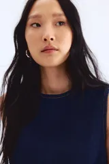 Vestido corto sin mangas en denim azul oscuro. Modelo con escote redondo y pinzas en el busto.