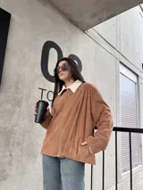 Campera marrón de pana con cierre frontal, cuello de piel sintética y bolsillos laterales.