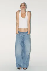 Pantalón de jean celeste de tiro alto, corte wide leg y largo hasta el tobillo. Incluye cinturón de la misma tela con trabillas y cierre frontal con cremallera, botón y gancho metálico.
