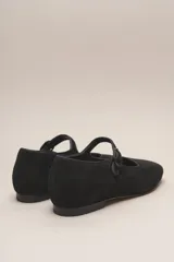 Zapato estilo Mary Jane color marrón, de cuero, con punta redondeada y tira sobre el empeine con hebilla.