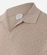 Camisa de poliéster y algodón color beige, con cuello polo en v, mangas cortas y textura trenzada.