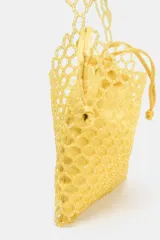 Bolso mini tipo saca color amarillo, con cuerpo de abalorios, asa de hombro y asa bandolera de cadena. Bolsita interior con cierre fruncido.