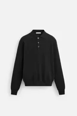 Polo de manga larga color negro, de punto tejido en hilatura de algodón, corte relaxed fit, con cuello solapa y cierre frontal de botonadura.