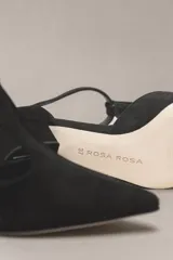 Sandalia de cuero color bordó, con acabado charolado, punta fina y tacón cuadrado de 5 cm. Presenta una tira en forma de T sobre el empeine y una correa con hebilla alrededor del tobillo.