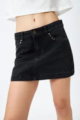 Minifalda de jean celeste con tiro bajo y detalle de tachas metálicas en los bolsillos.