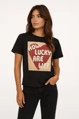 Remera de algodón color crudo con estampado de un labial rojo y texto en color bordó que dice "It's OK to wear lipstick". Corte clásico, cuello redondo y mangas cortas.
