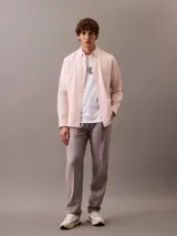 Remera blanca de algodón con cuello redondo y manga corta. Presenta un logo bordado de CK Shield en el pecho.