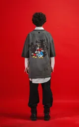 Remera oversize de algodón premium, color gris oscuro con efecto gastado (acid wash), con cuello redondo y manga corta. Presenta un pequeño estampado de Mickey Mouse en el pecho.