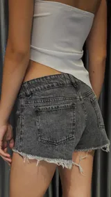 Short de jean gris con pequeños apliques brillantes, tiro bajo y terminación desflecada.
