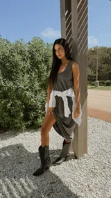 Vestido midi negro sin mangas, con escote en V, espalda alta y bolsillos laterales.