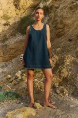 Vestido corto de denim azul, con escote en U y sisas bajas.