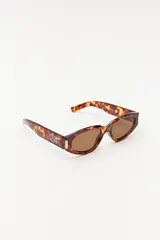 Lentes de sol de acetato color carey con forma ovalada y lentes marrones.