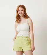 Musculosa blanca de punto acanalado con escote cuadrado, tirantes finos y dobladillo ondulado.