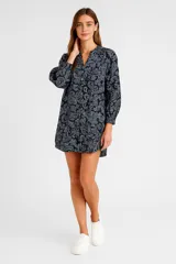 Vestido corto azul marino con estampado paisley en blanco, corte holgado, cuello mao y mangas largas abullonadas.