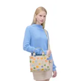 Bolso tote pequeño de lona color beige con estampado de margaritas de colores, cierre superior con cremallera, asas superiores de lona resistente y correa de cincha ajustable y extraíble.