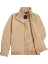 Campera color beige de Tommy Hilfiger, con cuello alto y cierre de cremallera. Tiene dos bolsillos laterales y logo engomado de Tommy Hilfiger bordado en la manga.