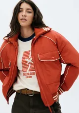 Campera bomber color ladrillo con cierre frontal, cuello alto y puños tejidos a rayas blancas y marrones.