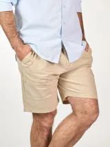 Bermuda de lino color beige, con diseño clásico y bolsillos laterales.