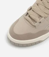 Championes urbanos color beige, confeccionados en material sintético, con recortes laterales, cordones y suela alta con detalles contrastantes.