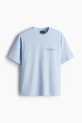 Remera celeste de corte holgado con cuello redondo y estampado frontal con la frase "Grand Lake Nature Club".