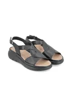 Sandalias de cuero color gris claro con tiras cruzadas y elástico. Suela de plataforma blanca.