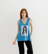 Musculosa celeste con cuello en V y estampa de una figura femenina en blanco y negro.