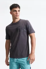Remera gris de manga corta con cuello redondo y estampado tipográfico en el frente.