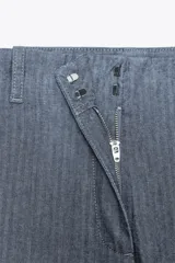 Pantalón de tiro alto con trabillas, bolsillos laterales y de parche en la espalda. Cierre frontal con cremallera y ganchos metálicos.