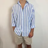 Camisa de lino a rayas verticales color beige y blanco, de corte holgado y manga larga con puños abotonados.