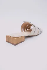 Mules color crudo con capellada trenzada de cuero y taco de madera de 3 cm.