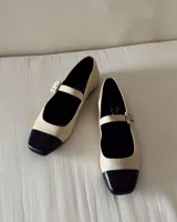 Ballerina de diseño clásico, con punta negra y parte superior beige.