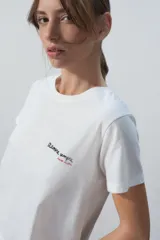Conjunto de pijama corto blanco, compuesto por una remera de algodón con estampado de texto en el pecho y un short con estampado de corazones.