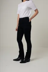 Jean negro de tiro alto, corte recto slim, con diseño clásico de cinco bolsillos y cierre frontal con botón metálico.