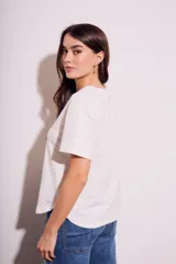 Remera blanca de algodón texturizado con cuello redondo y mangas cortas.