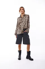 Camisa de poliéster con estampado animal print de leopardo, con cuello clásico, cierre frontal con botones y mangas largas.