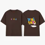 Camiseta celeste de manga corta con cuello redondo y estampado frontal de tres recipientes con cereales. En la parte trasera tiene un estampado grande con el texto "iUTTAi STARS" y un plato con cereales.